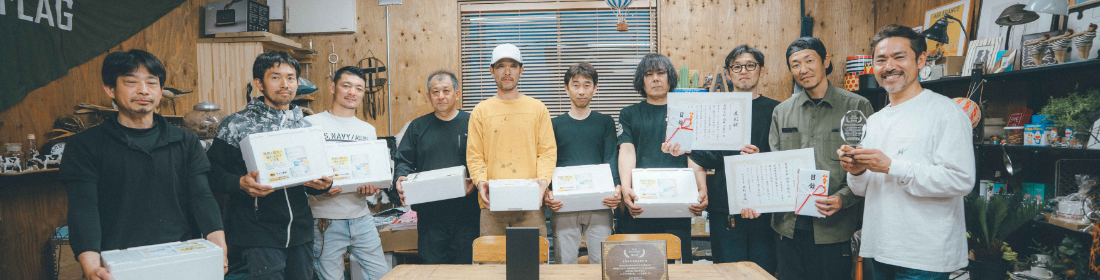 表彰状をもつスタッフ写真